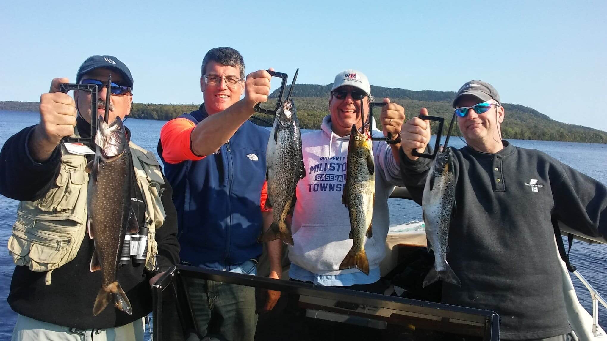 Four men proudly display their fish catch.