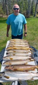 Guest displaying a full catch from a fishing charter in Moosehead Lake Maine