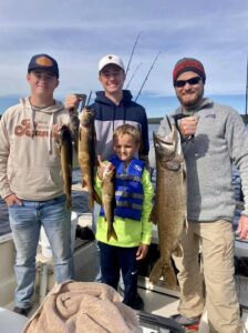 A family holding up their catches on a Moosehead Lake Fishing Charter