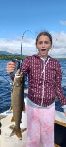 guest holding fish on a moosehead lake fishing charter in maine