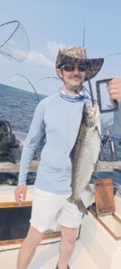 Guest Holding Up a salmon on a fishing charter in Greenville, Maine